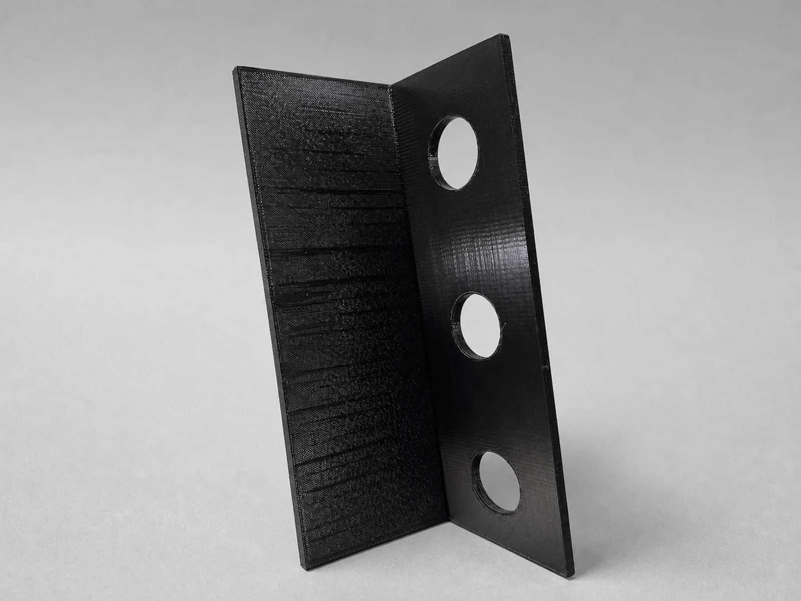 Schwarzer 3D-gedruckter Montagewinkel mit drei Bohrungen